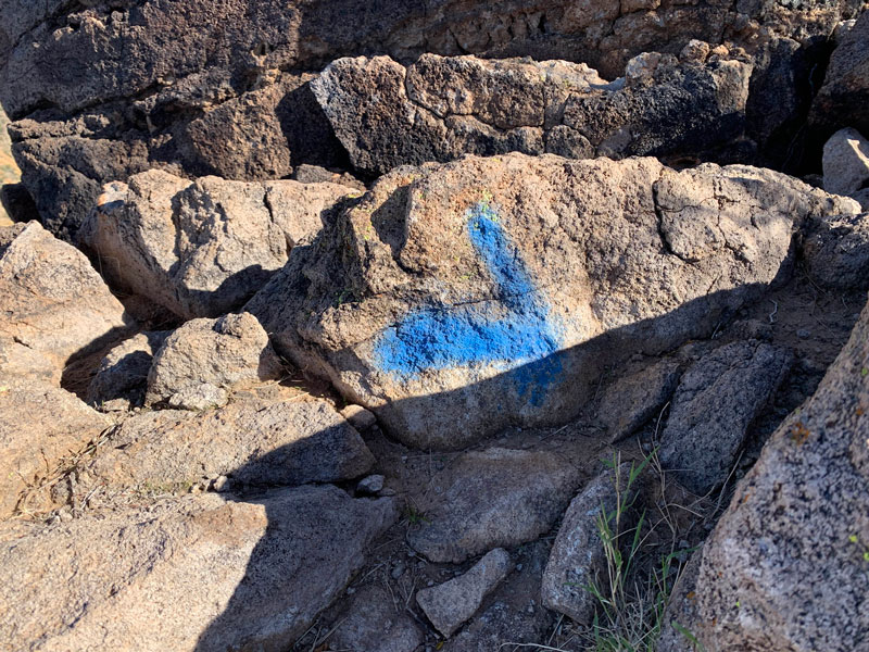 Spray paint graffiti on Pass Mountain Ridgeline Trail