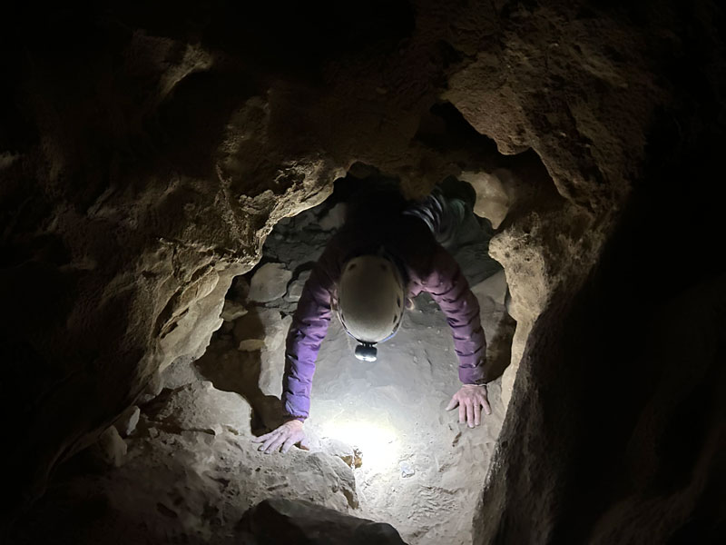 Crawling through a tunnel in Coronado Cave